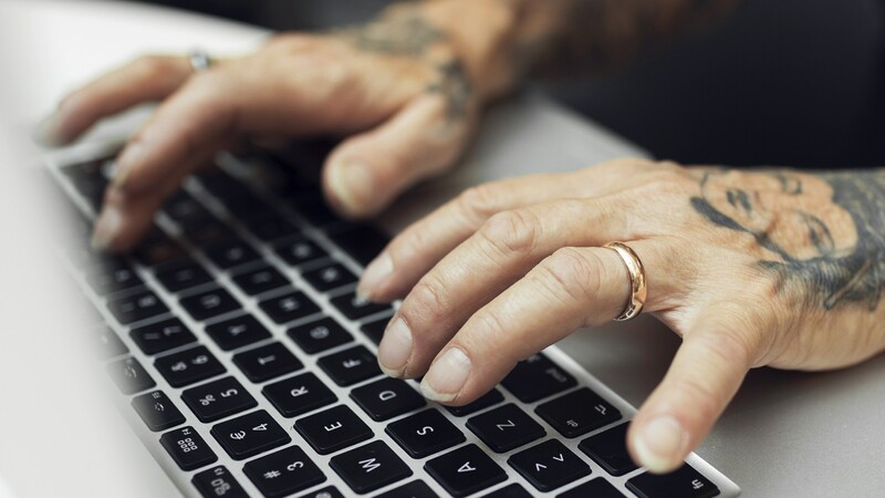 tattooed hands on keyboard