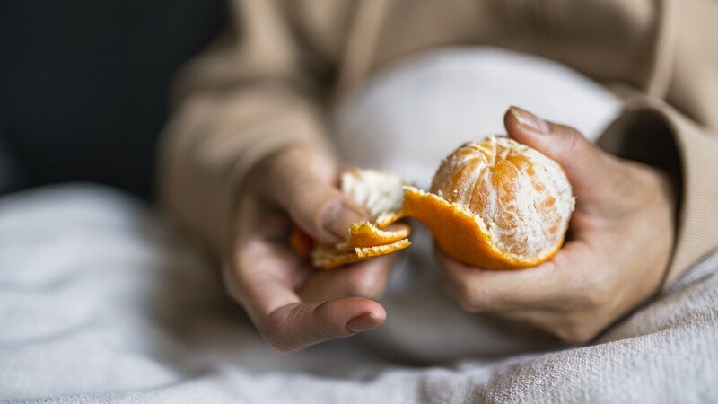 hands peel citrus fruit